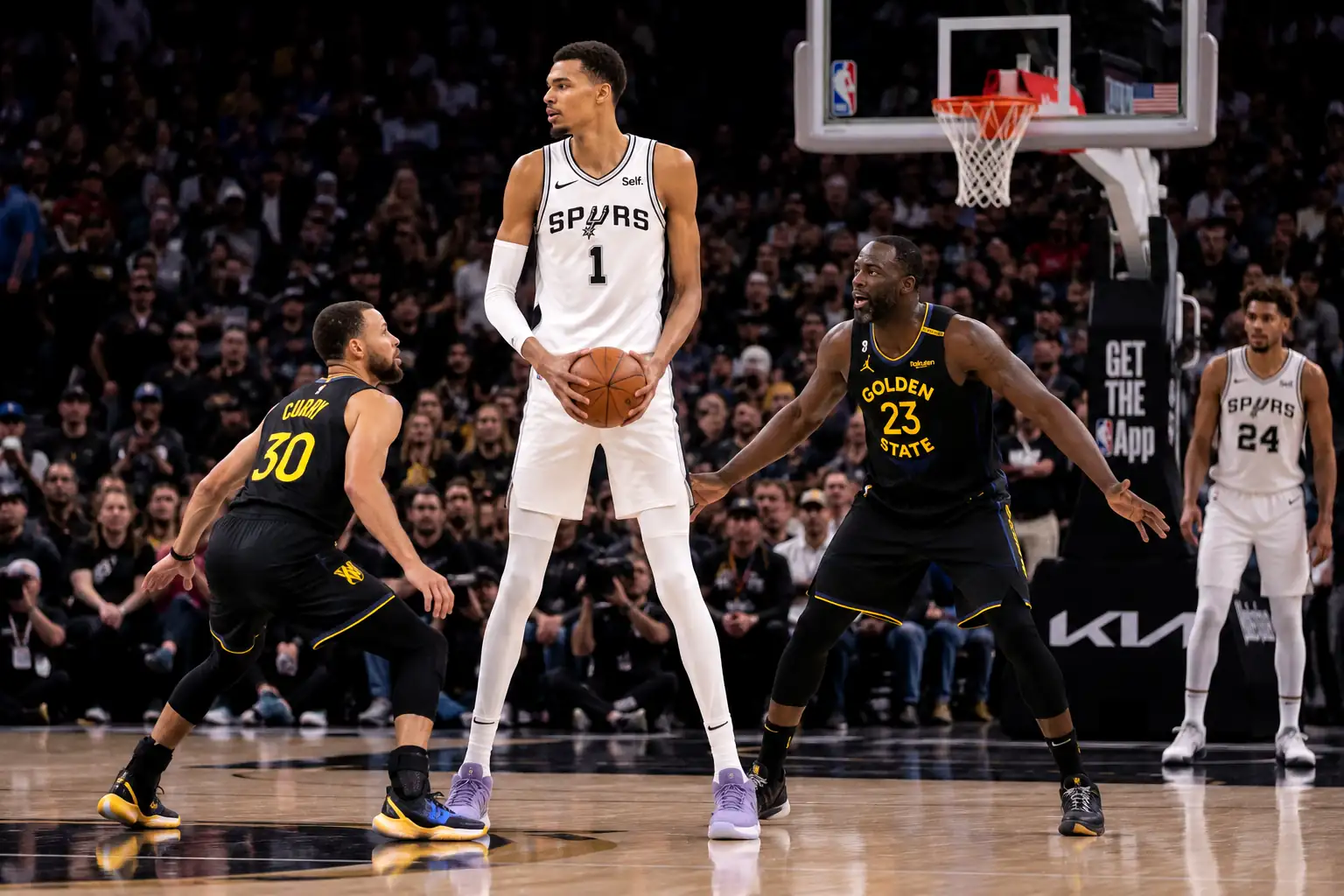 joueur de basket très grand tenant le ballon face à des défenseurs plus petits sur un parquet professionnel